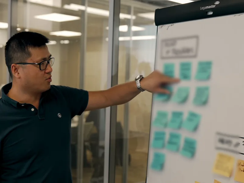 Stéphane Thanasack montre des post-its sur un tableau de priorisation.
